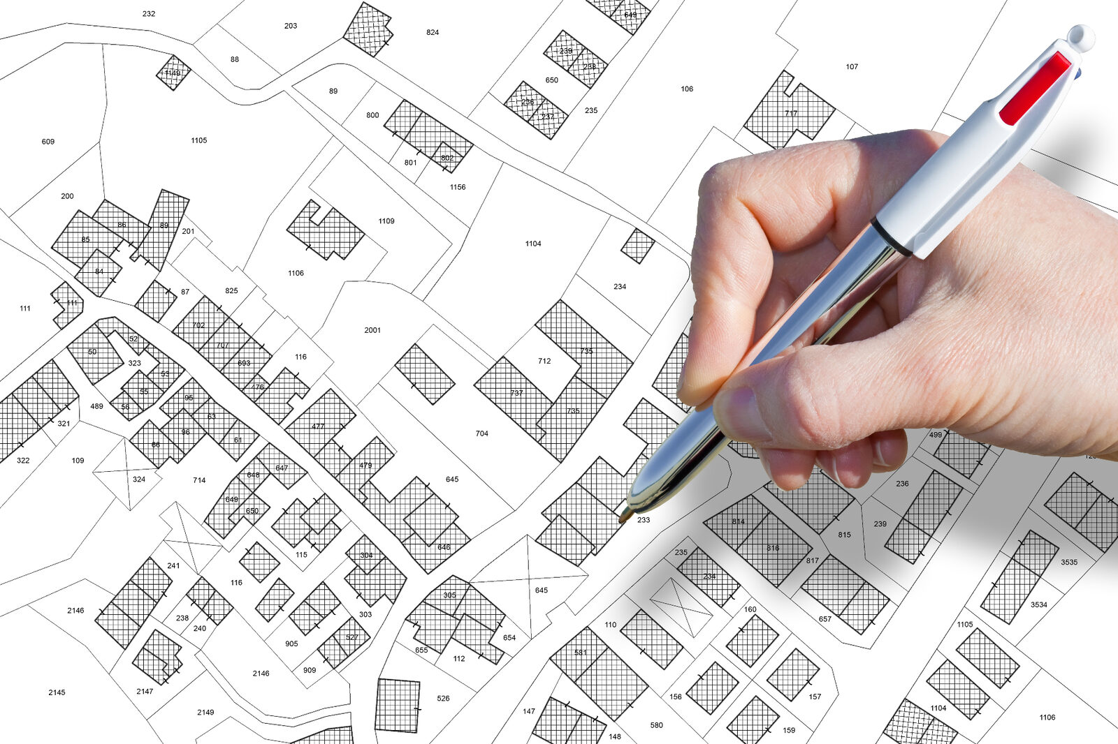 Hand marking a property title plan illustrating land ownership and caveat interests in Victoria